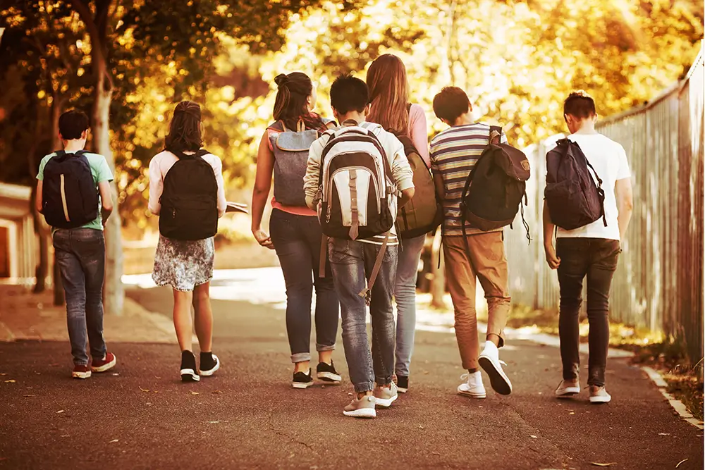 Varios adolescentes caminan con sus mochilas, posiblemente, tras salir del insituto.