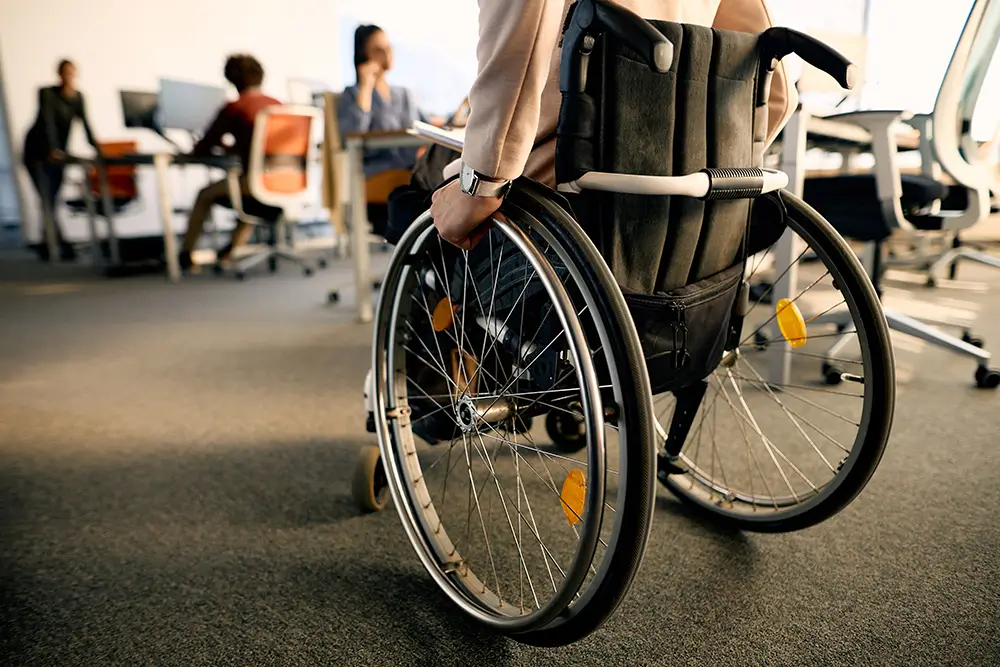 Persona en silla de ruedas en un entorno laboral.