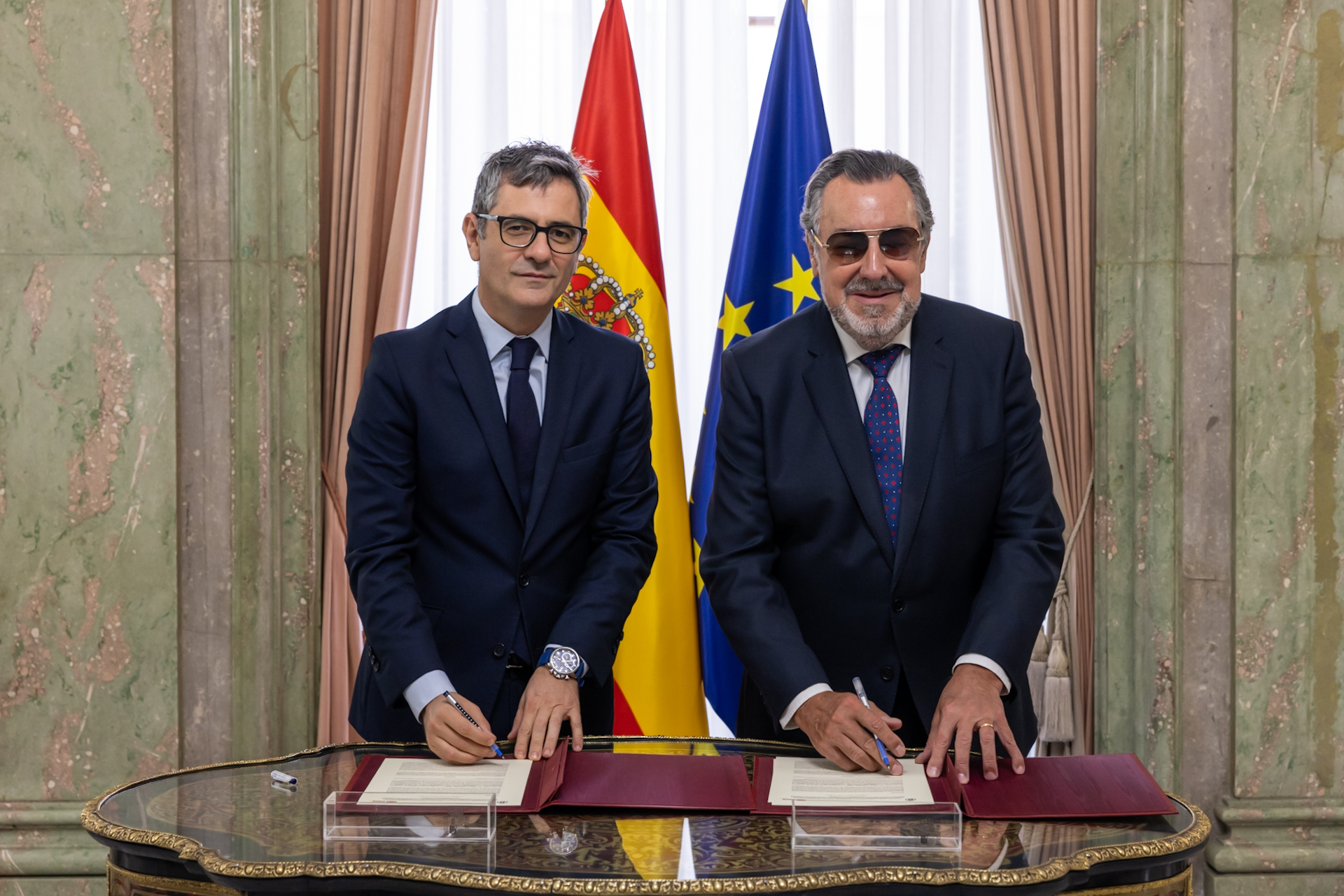 Félix Bolaños y Miguel Carballeda, posan firmando un convenio