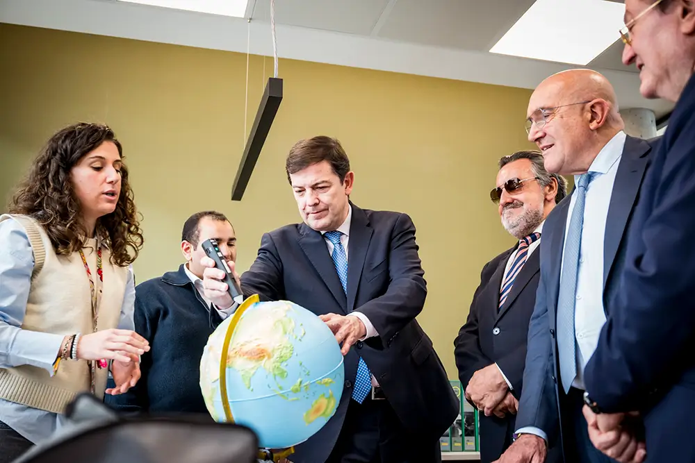 El presidente Mañueco prueba un globo terráqueo accesible en presencia de Miguel Carballeda
