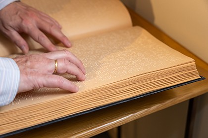 Manos leyendo un libro de Braille