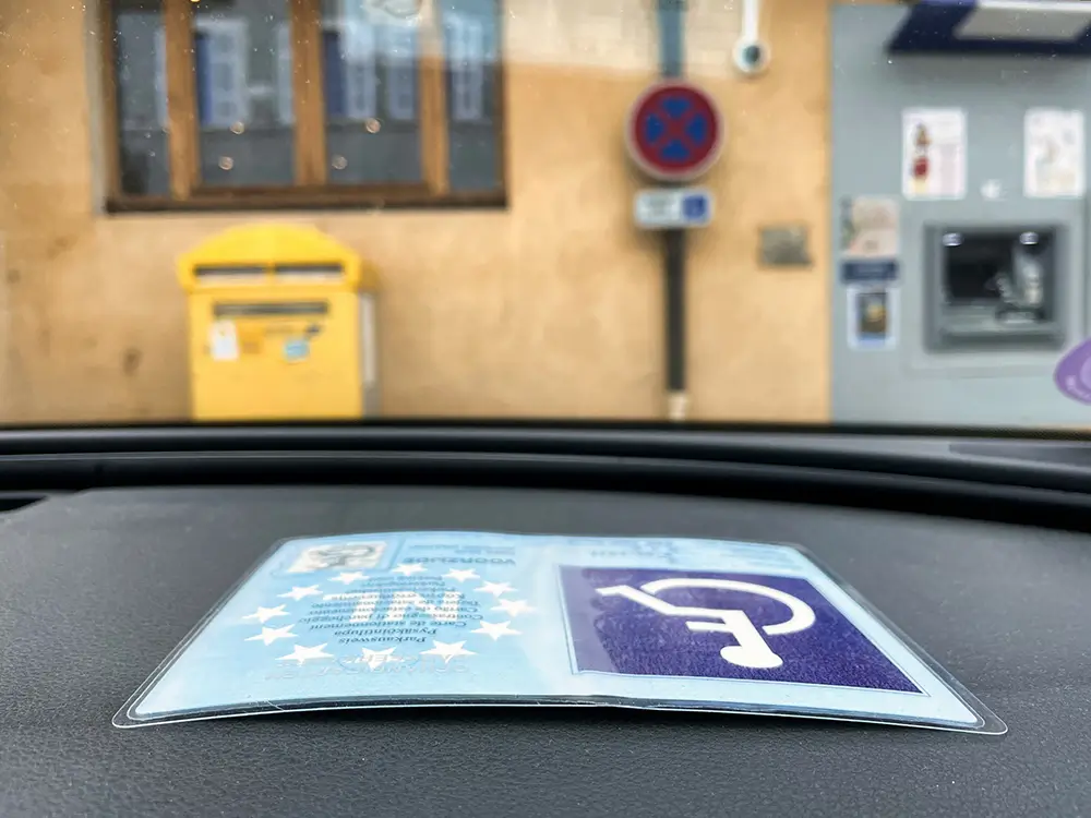 Tarjeta de aparcamiento para personas con discapacidad colocada en el salpicadero de un coche.