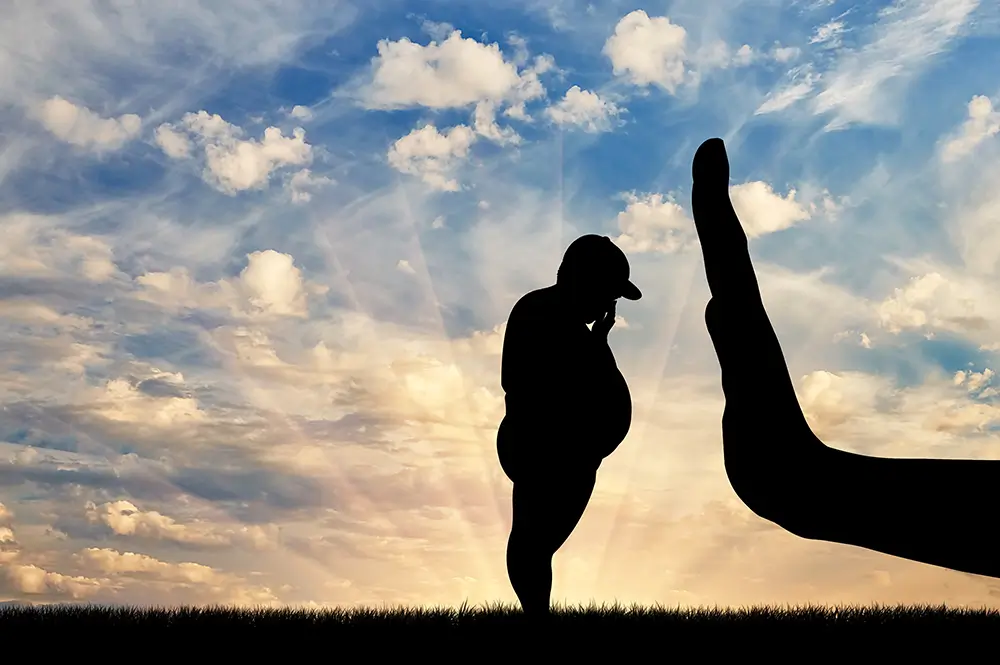 Menor con obesidad ante una mano que, simbólicamente, pide que ésta se detenga.