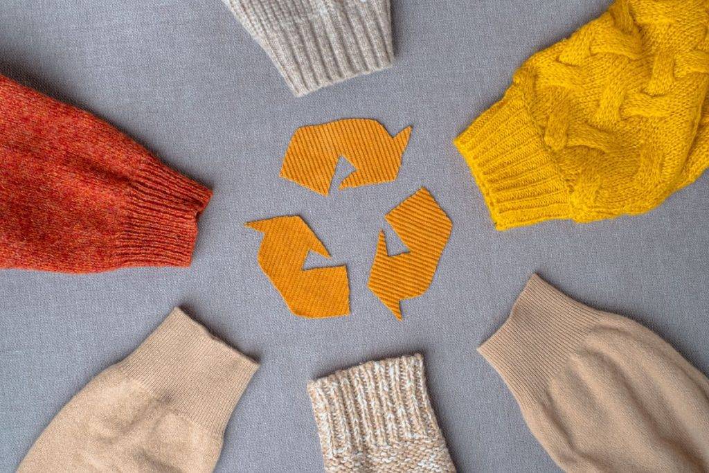 Prendas y símbolo del reciclaje.