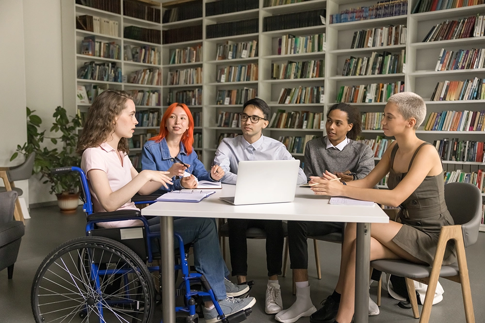 Jóvenes con y sin discapacidad trabajan en equipo sobre una mesa