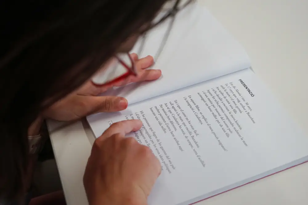 Una persona lee un libro de lectura fácil con las letras grandes.