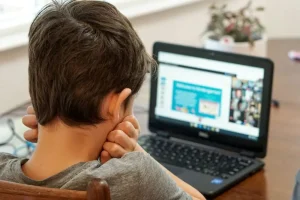 Un niño de espaldas ante una pantalla digital