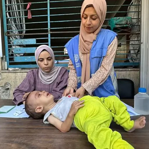 Un niño pequeño es evaluado por desnutrición por una trabajadora de la UNRWA en la ciudad de Gaza.