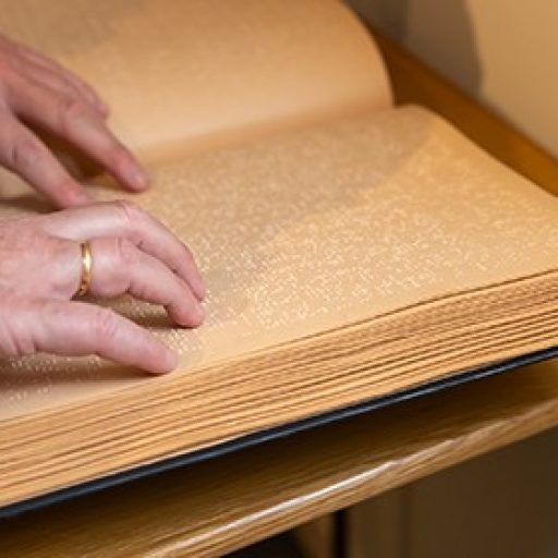 Manos leyendo un libro de Braille