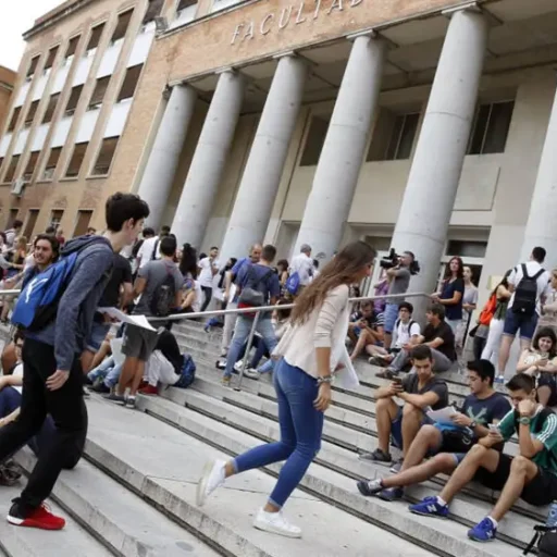 Numerosos jóvenes frente a un edificio universitario.